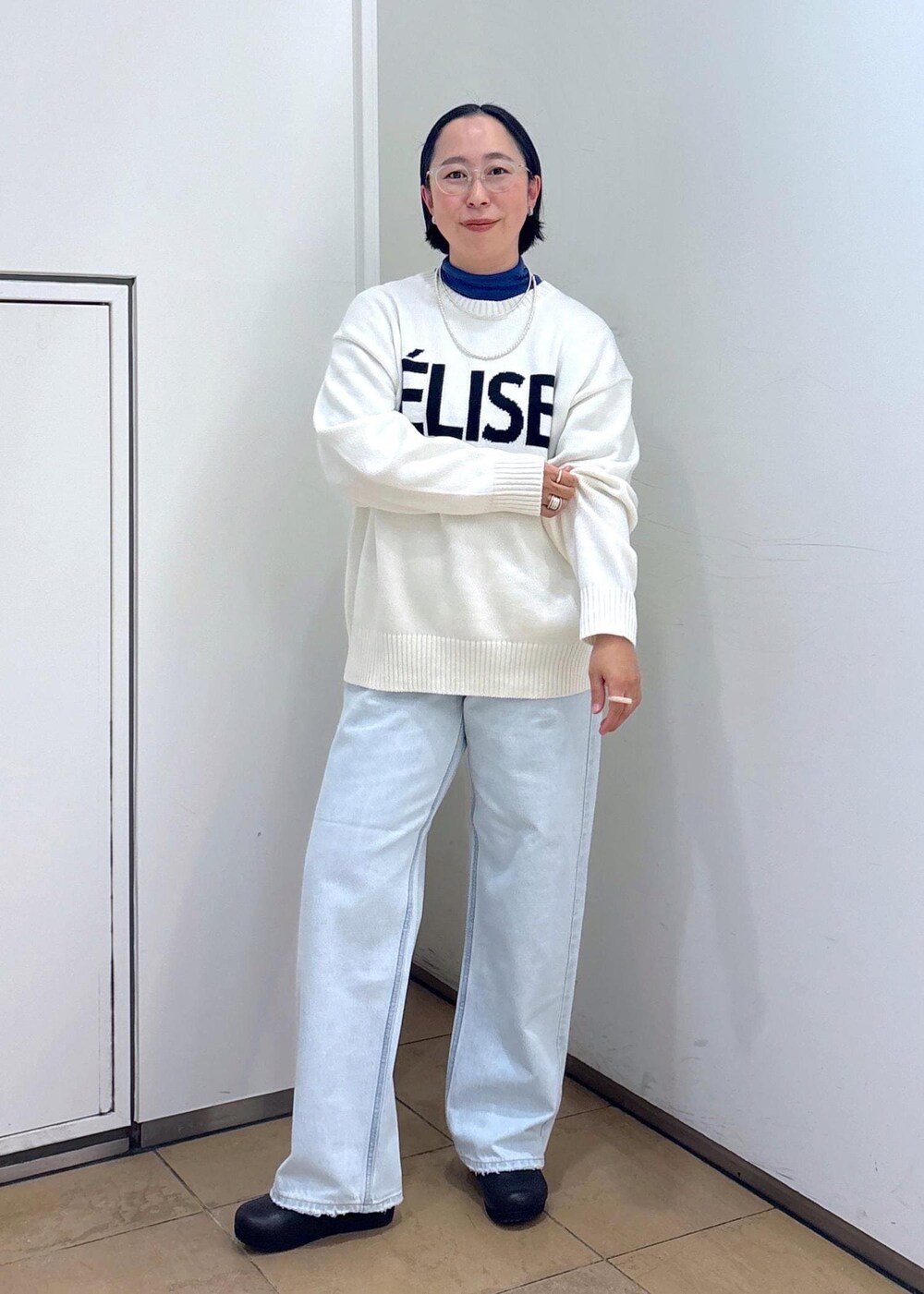 ホワイト系のニット/セーター、シルバー系のショルダーバッグ、ブルー系のデニムパンツを着用したレディースの冬コーディネートの5枚目の写真