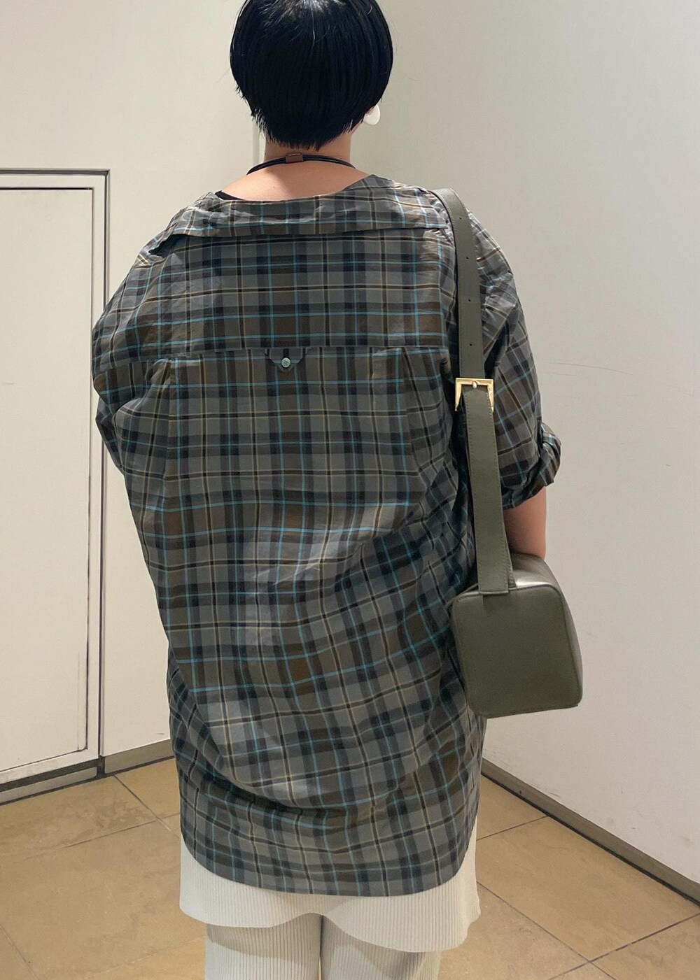 グリーン系のショルダーバッグ、ベージュ系のタンクトップ、ブルー系のシャツ/ブラウスを着用したレディースの秋コーディネートの8枚目の写真