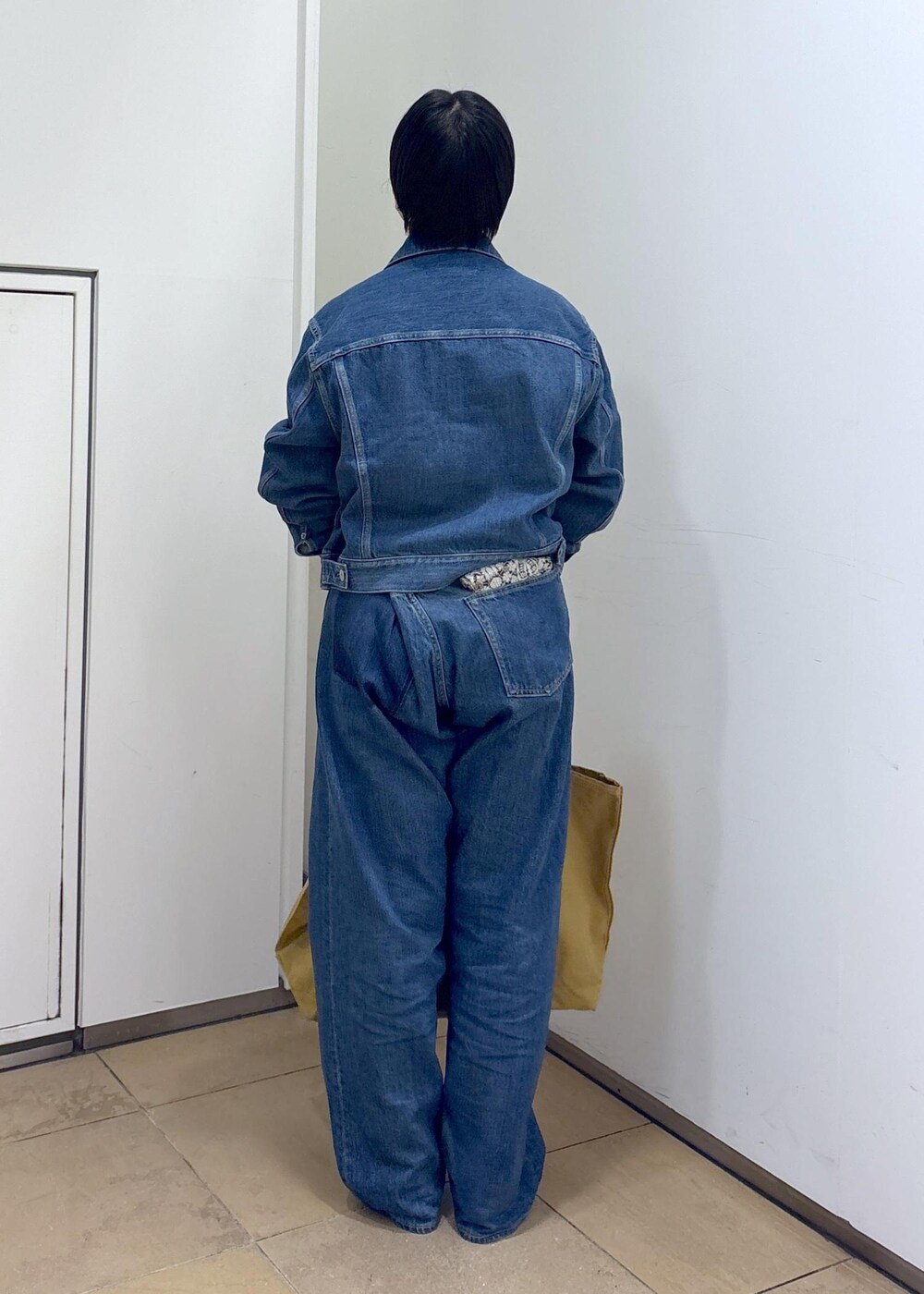 ブルー系のデニムジャケット、ブルー系のデニムパンツ、ブラック系のパンプスを着用したレディースの秋コーディネートの6枚目の写真