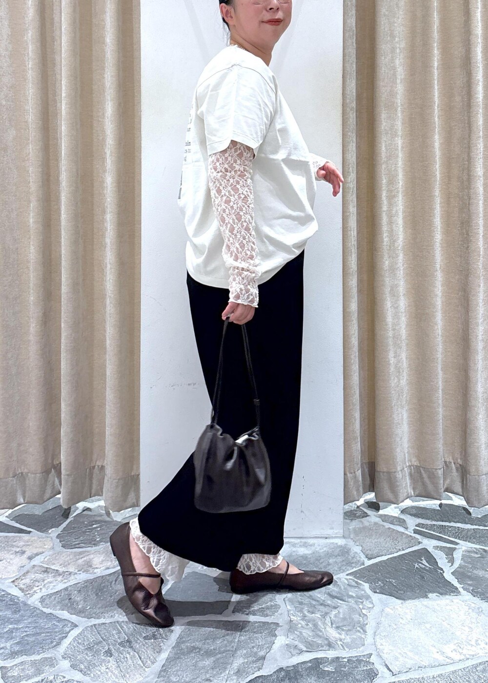 ブラック系のスカート、ホワイト系のその他トップス、ブラウン系のハンドバッグを着用したレディースの夏コーディネートの9枚目の写真