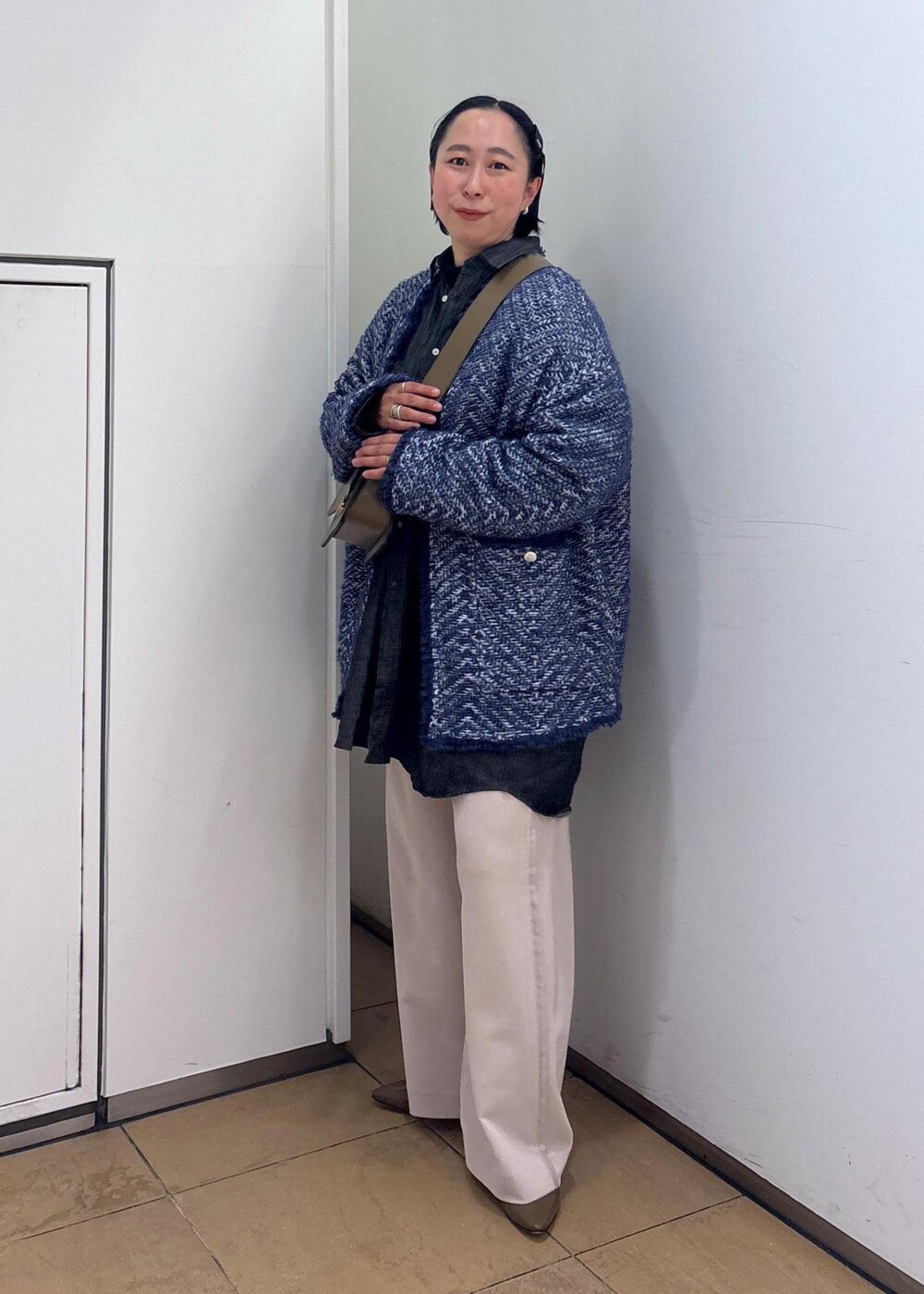 ブルー系のカーディガン/ボレロ、ブラウン系のショルダーバッグ、ホワイト系のその他パンツを着用したレディースの冬コーディネートの4枚目の写真