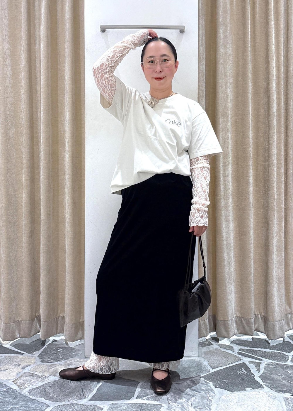 ブラック系のスカート、ホワイト系のその他トップス、ブラウン系のハンドバッグを着用したレディースの夏コーディネートの2枚目の写真