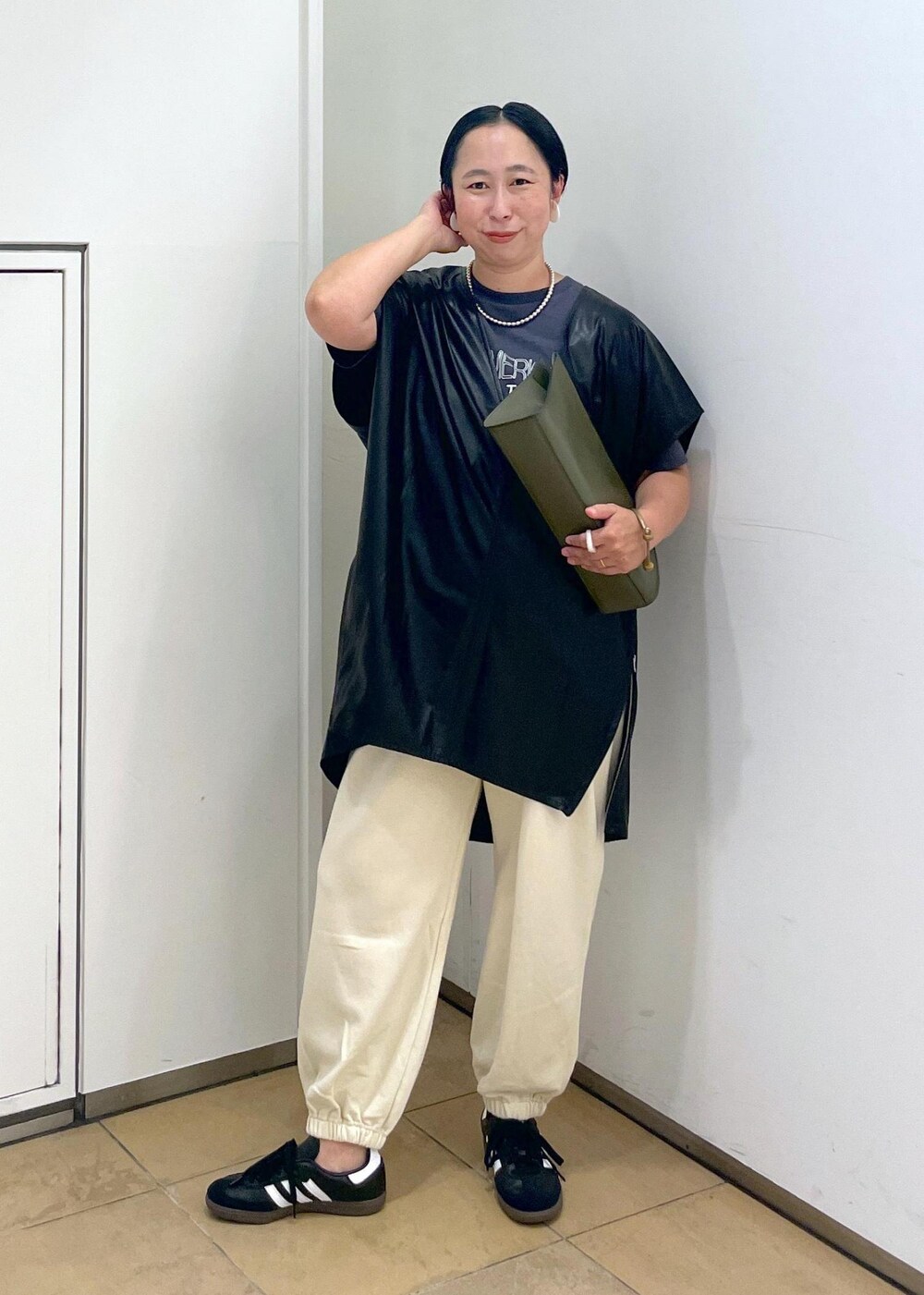 グリーン系のショルダーバッグ、ブラック系のTシャツ/カットソー、ホワイト系のスウェットパンツを着用したレディースの夏コーディネートの4枚目の写真