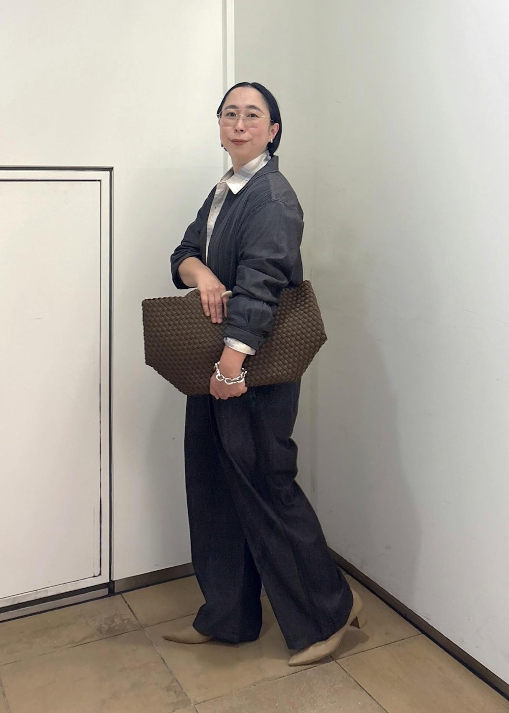 ベージュ系のパンプス、ブルー系のシャツ/ブラウス、イエロー系のトートバッグを着用したレディースの春コーディネートの5枚目の写真