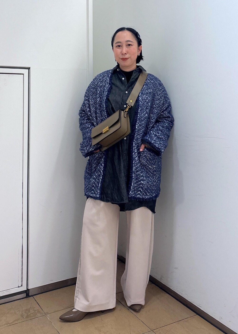 ブルー系のカーディガン/ボレロ、ブラウン系のショルダーバッグ、ホワイト系のその他パンツを着用したレディースの冬コーディネートの2枚目の写真