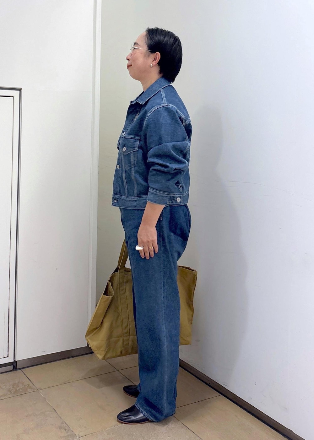 ブルー系のデニムジャケット、ブルー系のデニムパンツ、ブラック系のパンプスを着用したレディースの秋コーディネートの5枚目の写真