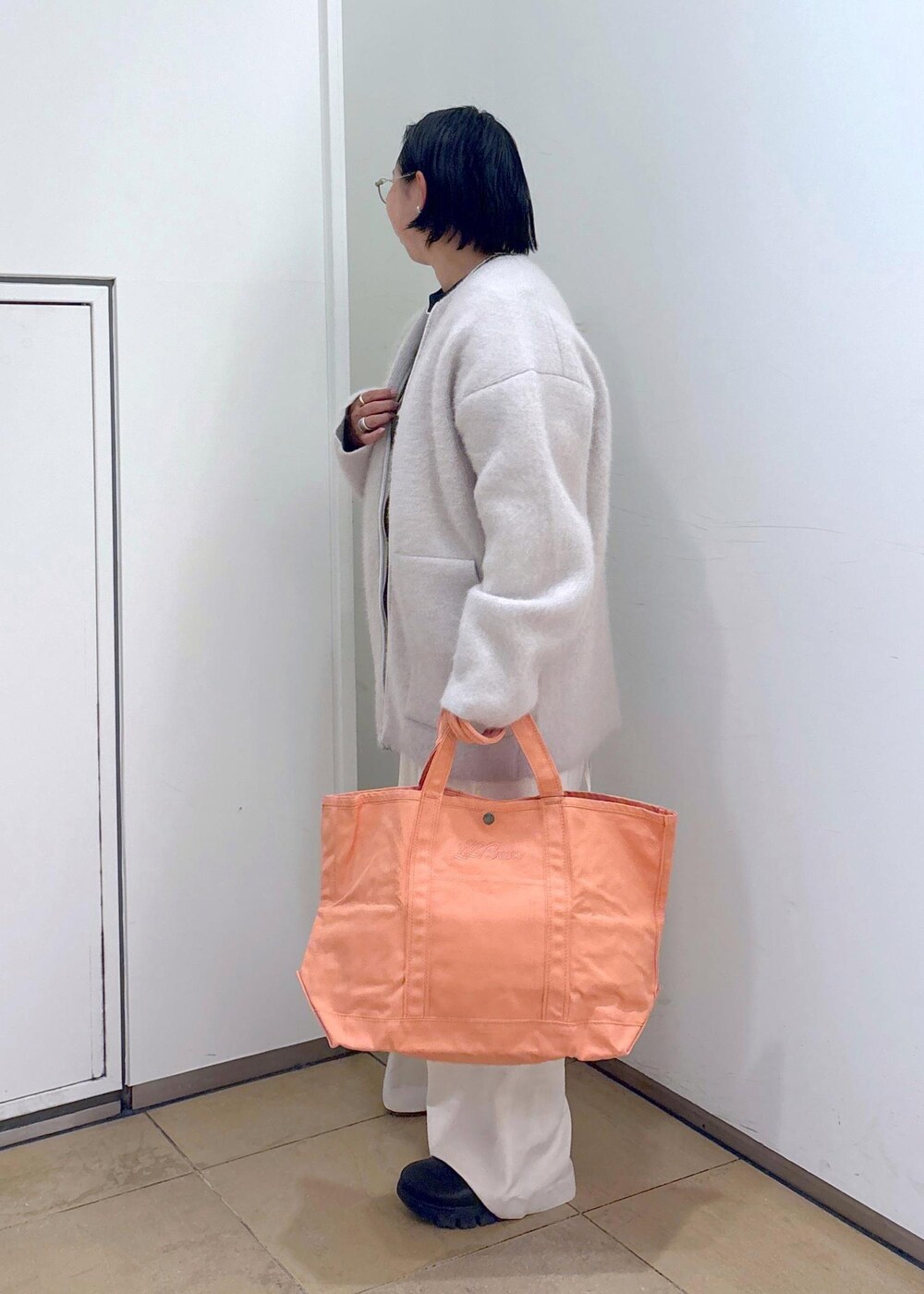 ブラック系のスウェット、グレー系のブルゾン、ホワイト系のサロペット/オーバーオールを着用したレディースの冬コーディネートの7枚目の写真