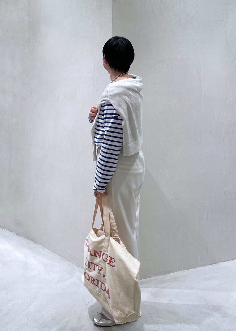 ブルー系のTシャツ/カットソー、シルバー系のバレエシューズ、ホワイト系のニット/セーターを着用したレディースの冬コーディネートの3枚目の写真