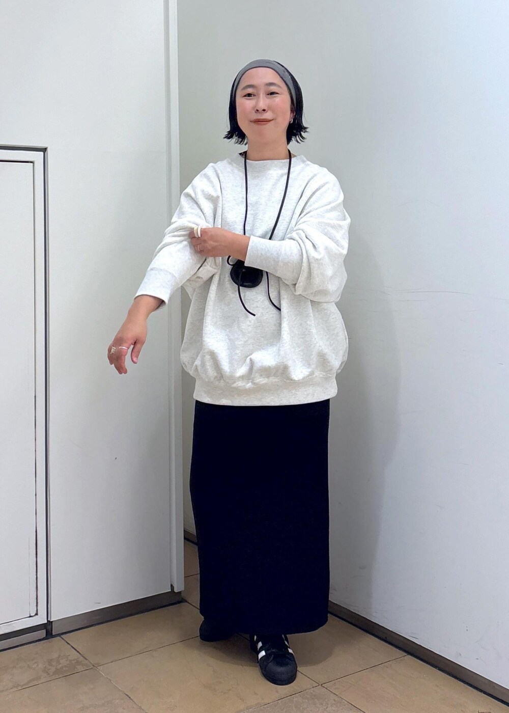 グレー系のスウェット、ブルー系のスカート、グレー系のヘアバンドを着用したレディースの冬コーディネートの3枚目の写真