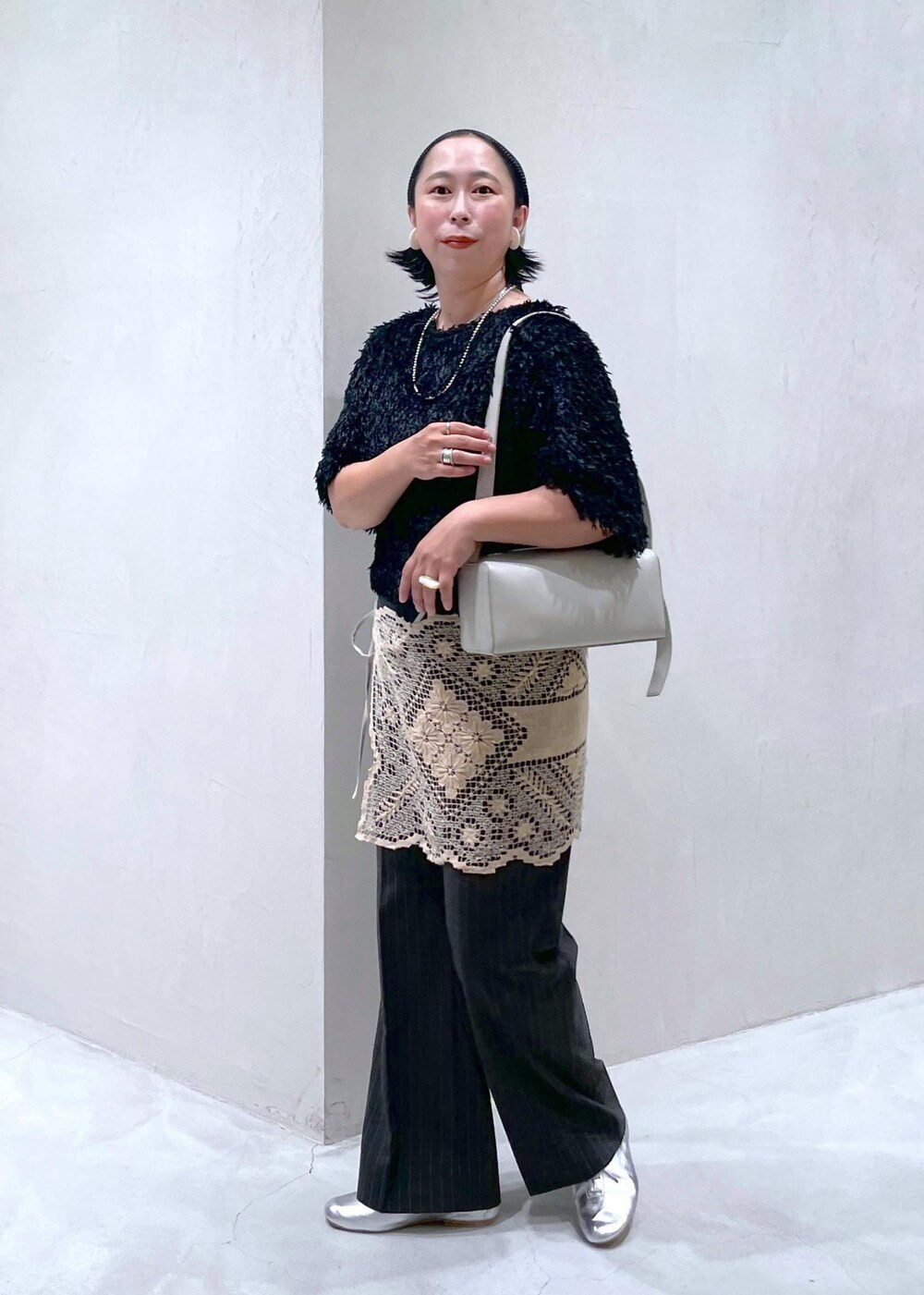 ブラック系のTシャツ/カットソー、グレー系のスラックス、グレー系のショルダーバッグを着用したレディースの夏コーディネートの3枚目の写真