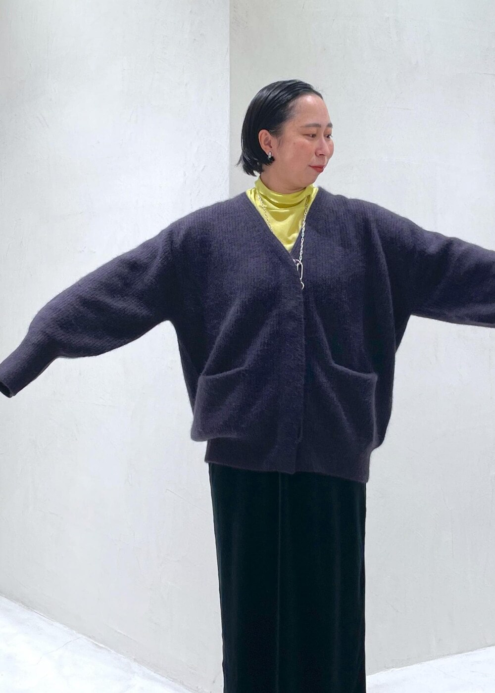 ブラック系のスカート、レッド系のカーディガン/ボレロ、グリーン系のTシャツ/カットソーを着用したレディースの秋コーディネートの4枚目の写真