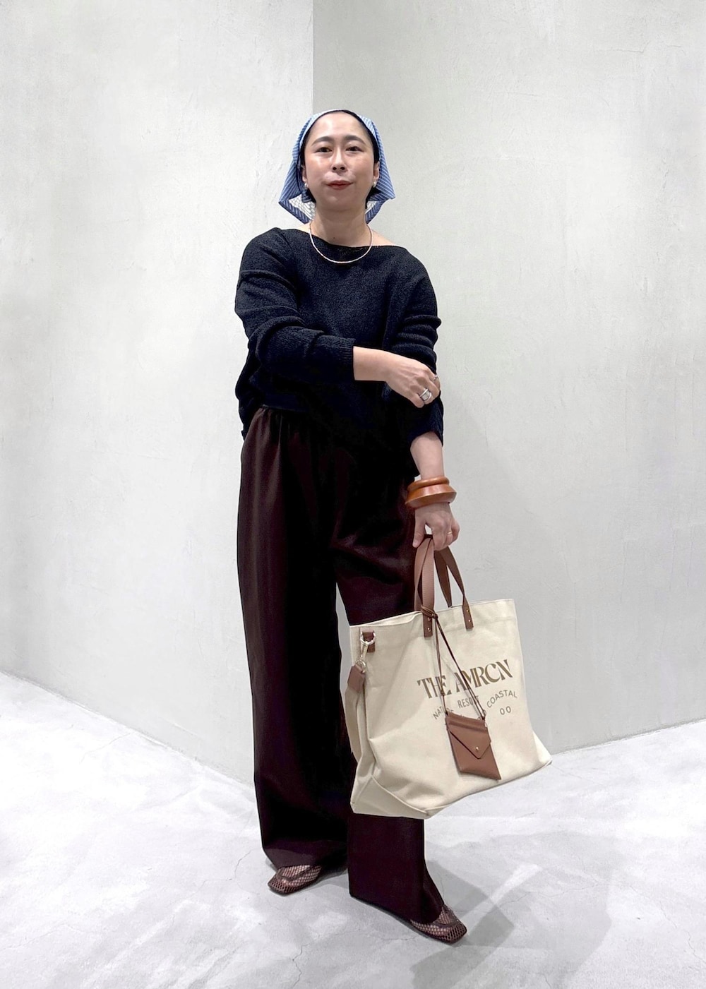 ブラウン系のその他パンツ、ベージュ系のトートバッグ、ブラウン系のローファーを着用したレディースの春コーディネートの2枚目の写真