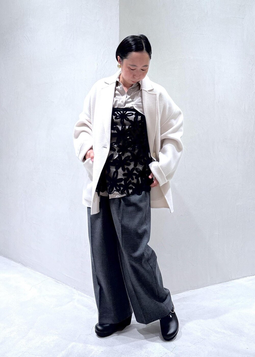 グレー系のスラックス、ブラック系のスカート、グレー系のシャツ/ブラウスを着用したレディースの秋コーディネートの2枚目の写真