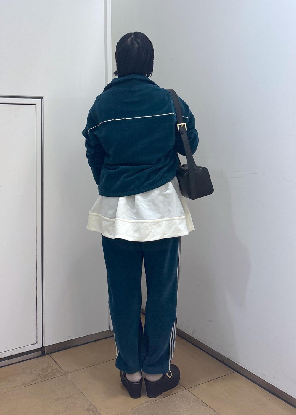 ブラック系のショルダーバッグ、ブラック系のタンクトップ、グリーン系のその他パンツを着用したレディースの冬コーディネートの6枚目の写真