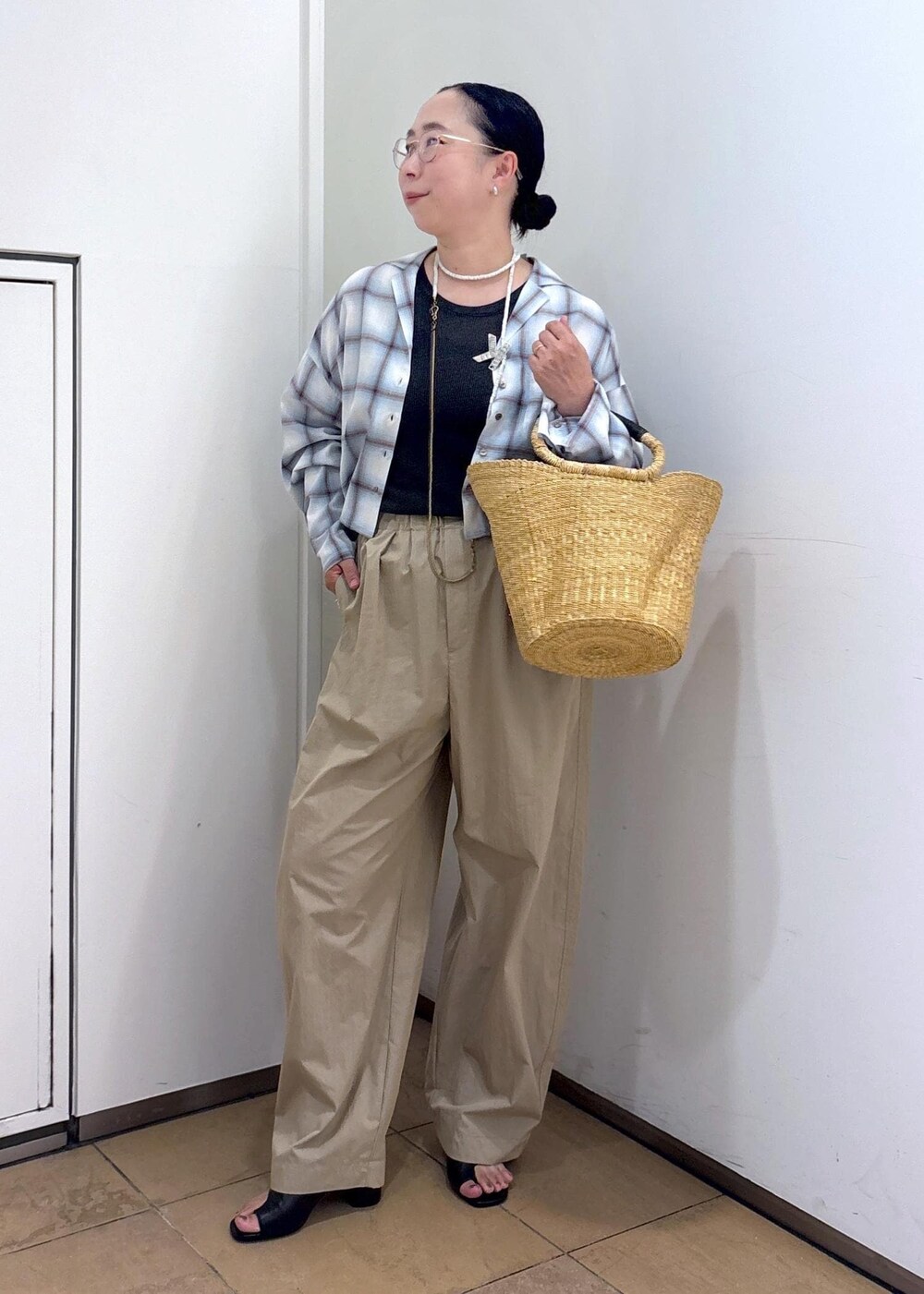 ホワイト系のトートバッグ、ブラック系のサンダル、グレー系のタンクトップを着用したレディースの夏コーディネートの5枚目の写真