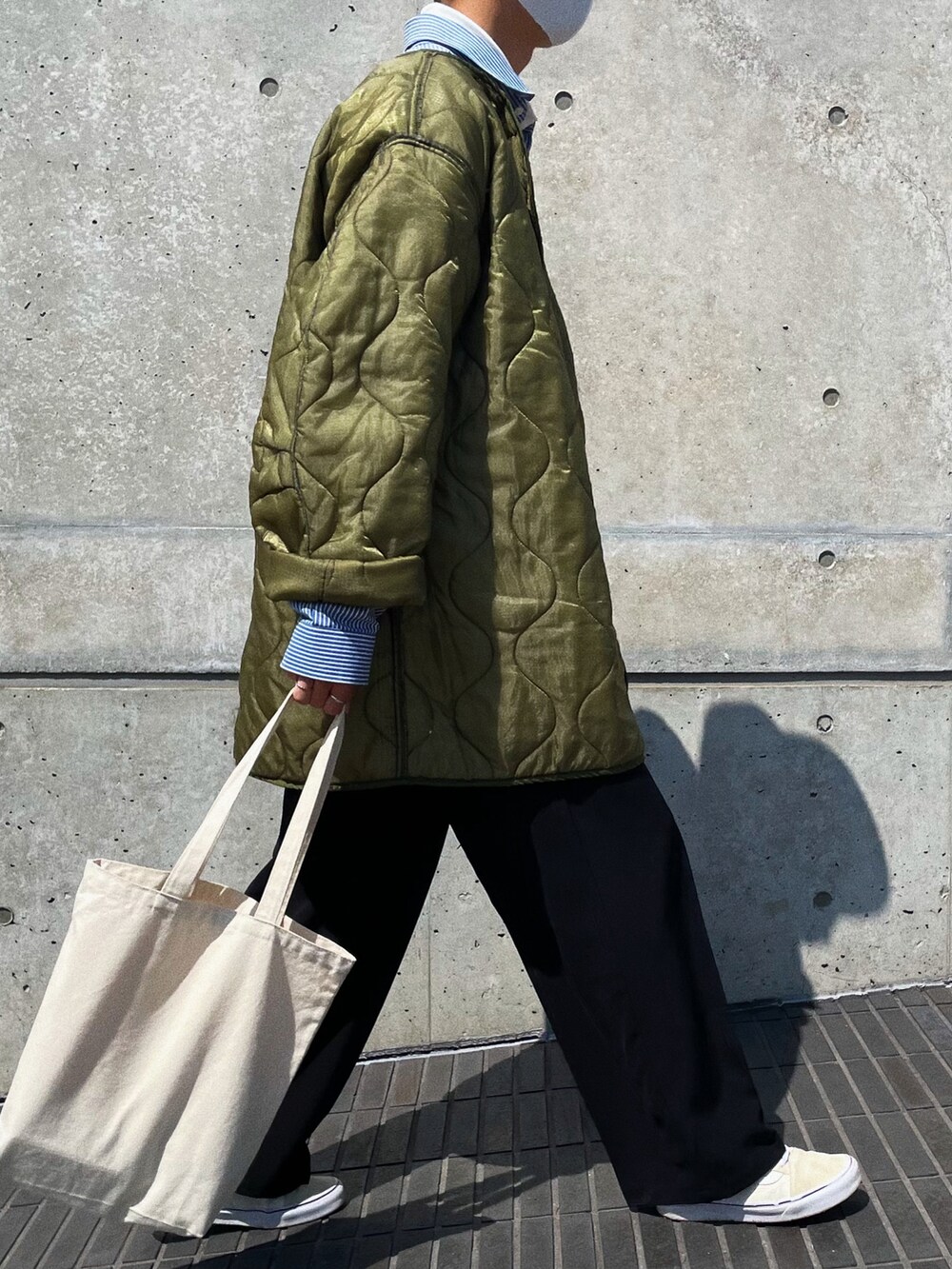 ブルー系のシャツ/ブラウス、ブラック系のスラックス、グレー系のスニーカーを着用したメンズの春コーディネートの2枚目の写真