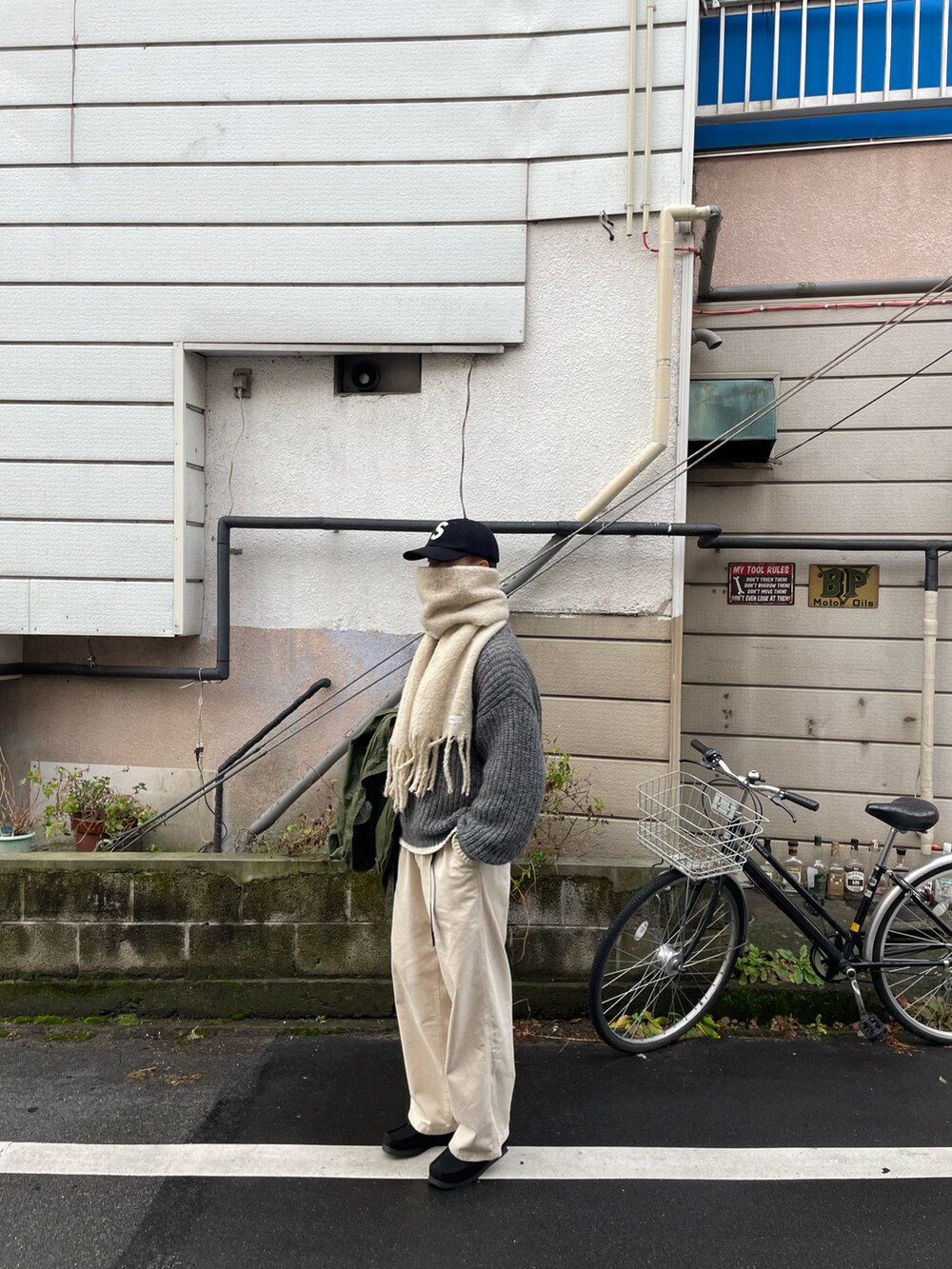 ベージュ系のトップス、グリーン系のミリタリージャケットを着用したメンズの冬コーディネートの5枚目の写真