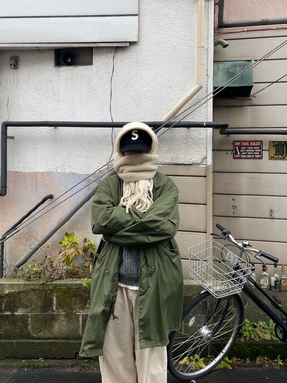 ベージュ系のトップス、グリーン系のミリタリージャケットを着用したメンズの冬コーディネートの3枚目の写真