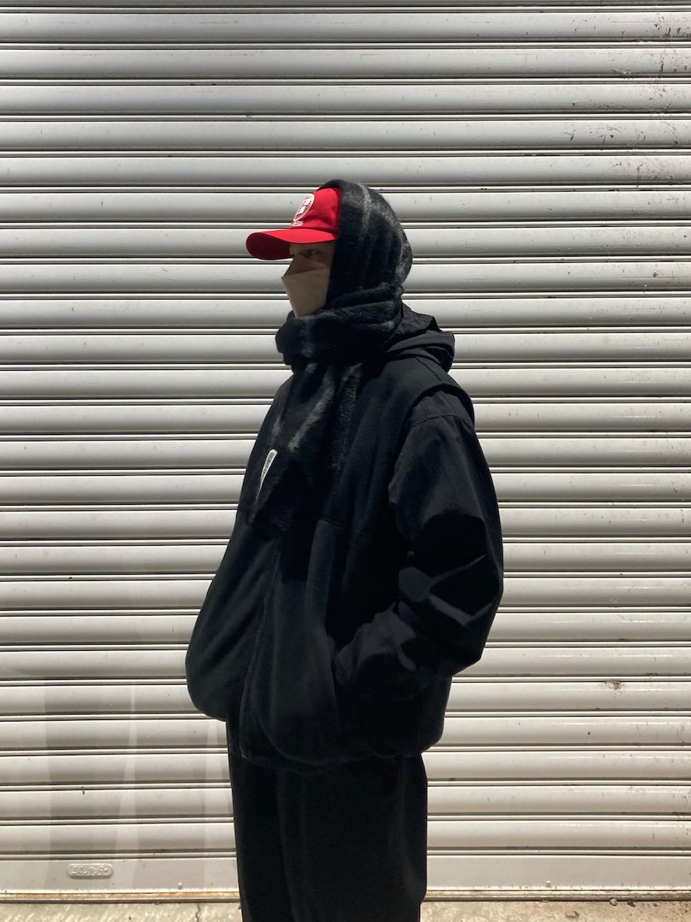 ブラック系のその他パンツ、ブラック系のスニーカー、ブラック系のナイロンジャケットを着用したメンズの冬コーディネートの2枚目の写真