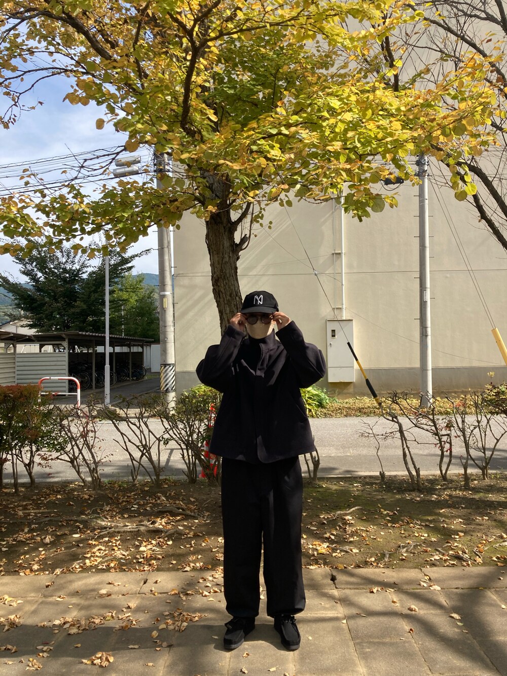 ブラック系のテーラードジャケット、ブラック系のナイロンジャケット、ブラック系のモカシン/デッキシューズを着用したメンズの秋コーディネートの2枚目の写真