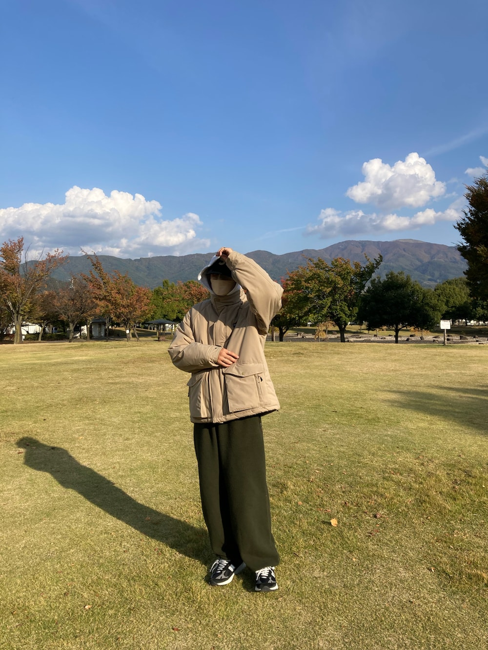 グリーン系のカーゴパンツ、ブラック系のスニーカーを着用したメンズの秋コーディネートの2枚目の写真
