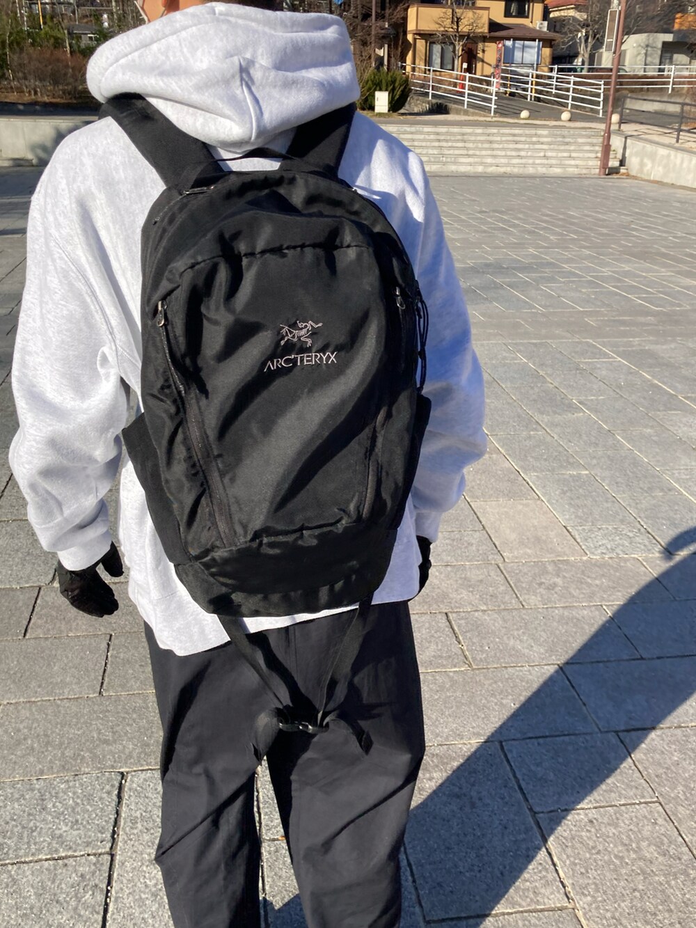 ホワイト系のパーカー、ブラック系のバックパック/リュック、ブラック系のカーゴパンツを着用したメンズの冬コーディネートの4枚目の写真