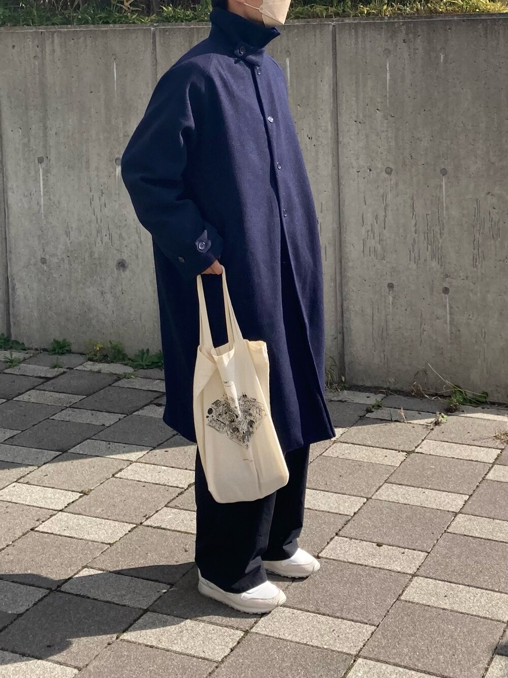 ブルー系のステンカラーコート、ブラック系のカーゴパンツ、ホワイト系のスニーカーを着用したメンズの秋コーディネートの4枚目の写真