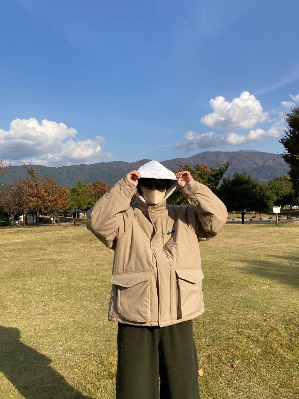 グリーン系のカーゴパンツ、ブラック系のスニーカーを着用したメンズの秋コーディネートの3枚目の写真