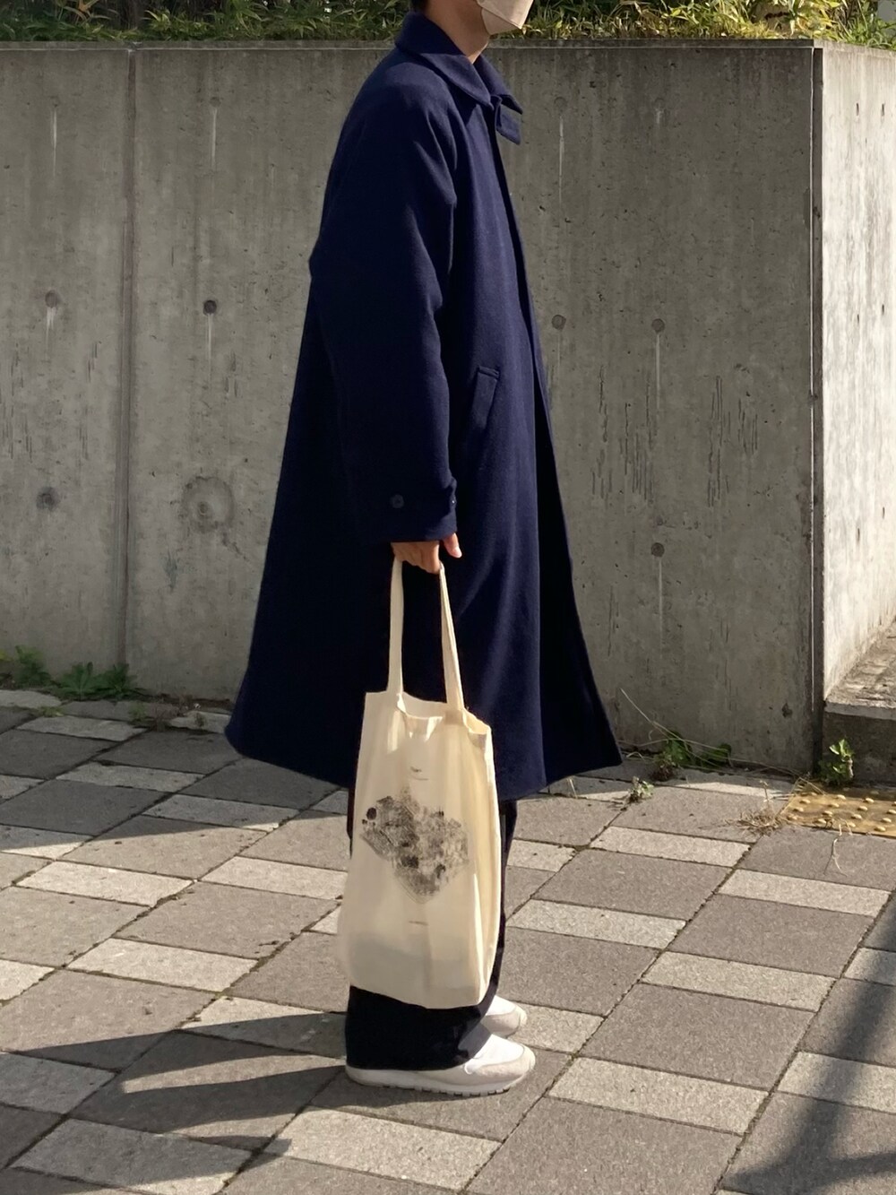 ブルー系のステンカラーコート、ブラック系のカーゴパンツ、ホワイト系のスニーカーを着用したメンズの秋コーディネートの3枚目の写真