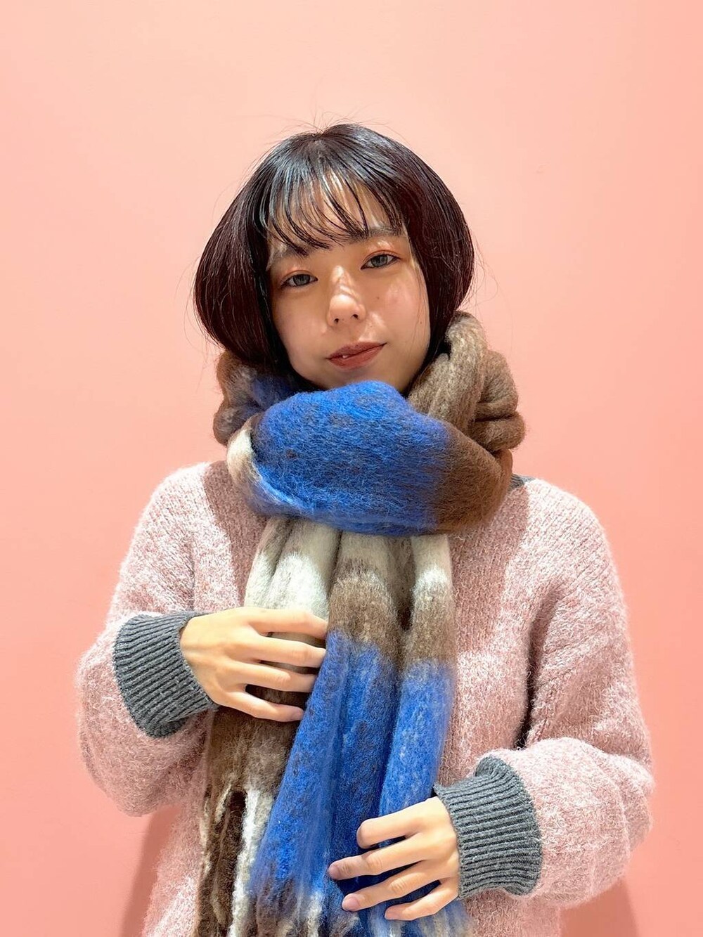 ピンク系のニット/セーター、ブラウン系のストール/ショールを着用したレディースの冬コーディネートの5枚目の写真
