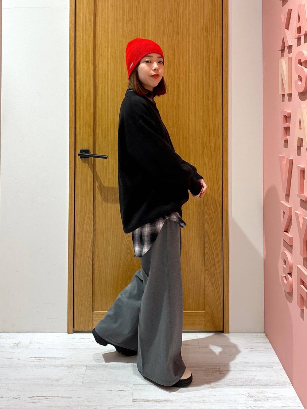 ブラック系のシャツ/ブラウス、ホワイト系のブーツ、ブラック系のニット/セーターを着用したレディースの秋コーディネートの2枚目の写真