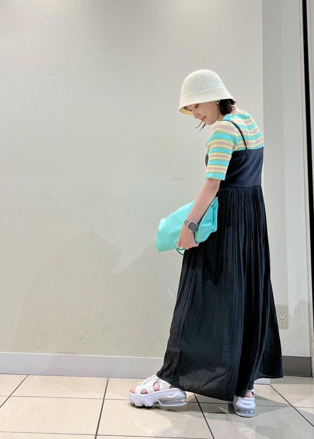 グリーン系のニット/セーター、グリーン系のトートバッグ、グレー系のワンピースを着用したレディースの夏コーディネートの2枚目の写真