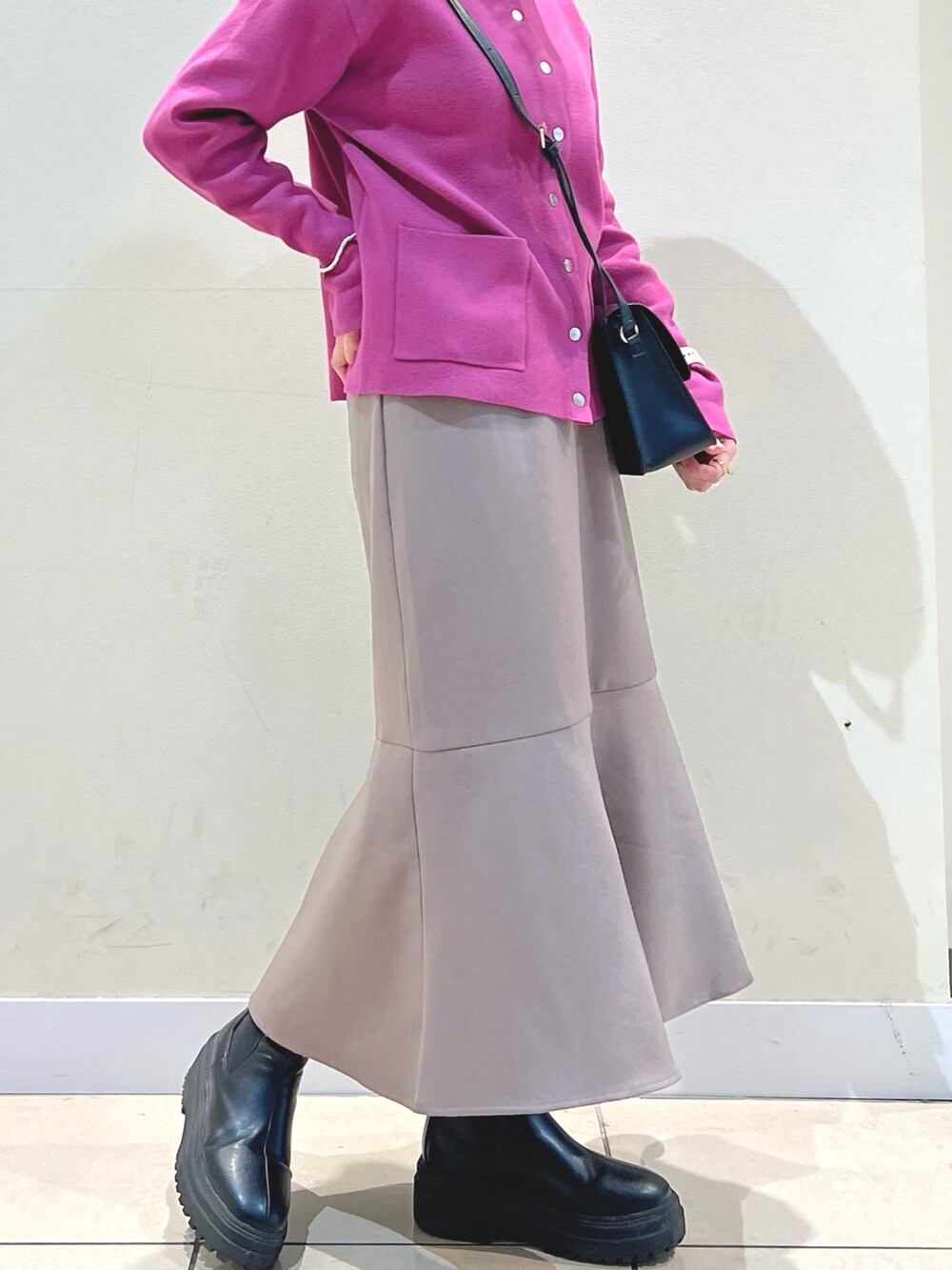 ブラウン系のショルダーバッグ、ピンク系のカーディガン/ボレロ、ホワイト系のTシャツ/カットソーを着用したレディースの秋コーディネートの3枚目の写真