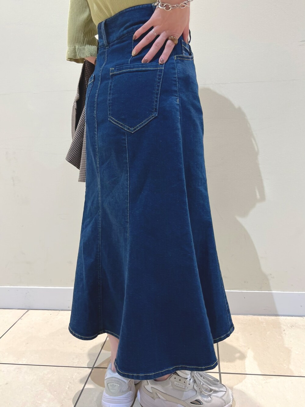 ブラック系のショルダーバッグ、ブラウン系のテーラードジャケット、ブルー系のデニムスカートを着用したレディースの夏コーディネートの4枚目の写真