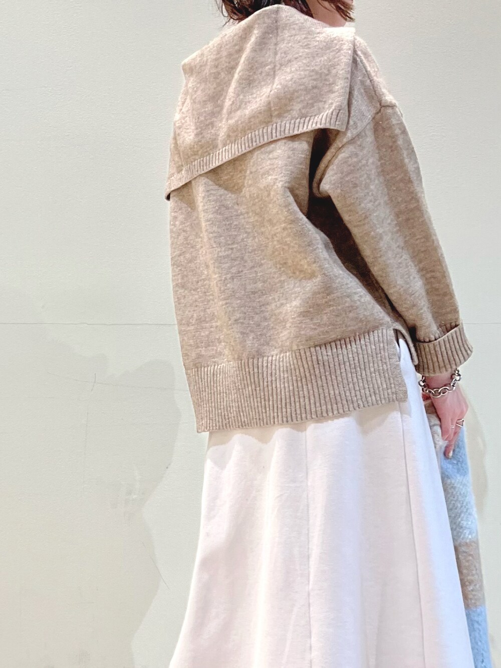 ベージュ系のニット/セーター、ピンク系のスカート、ブルー系のストール/ショールを着用したレディースの冬コーディネートの2枚目の写真