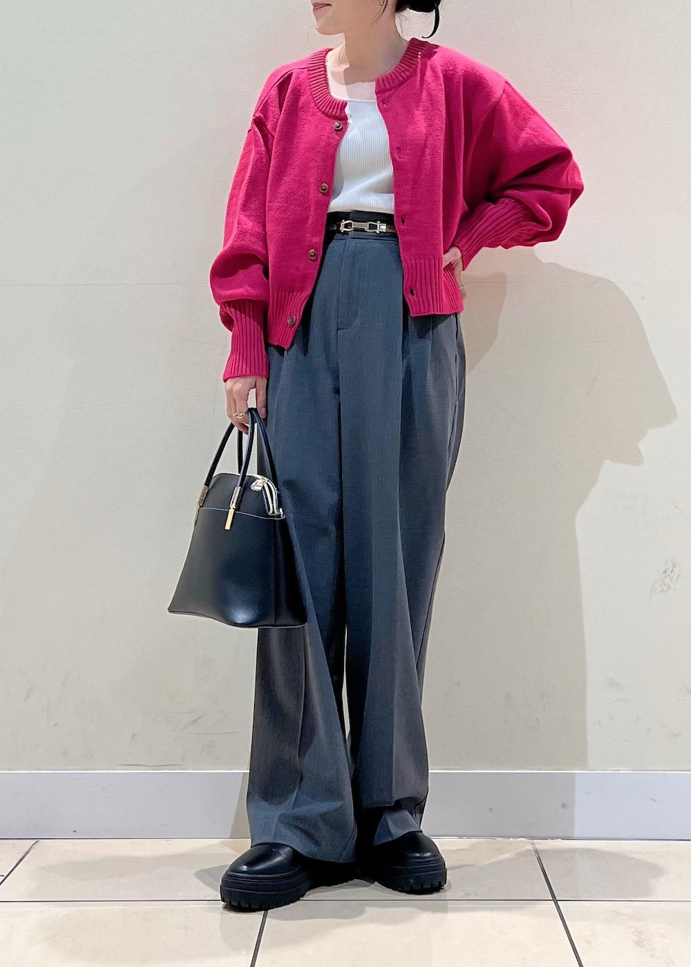 グレー系のタンクトップ、ブラック系のショルダーバッグ、ピンク系のカーディガン/ボレロを着用したレディースの秋コーディネートの3枚目の写真