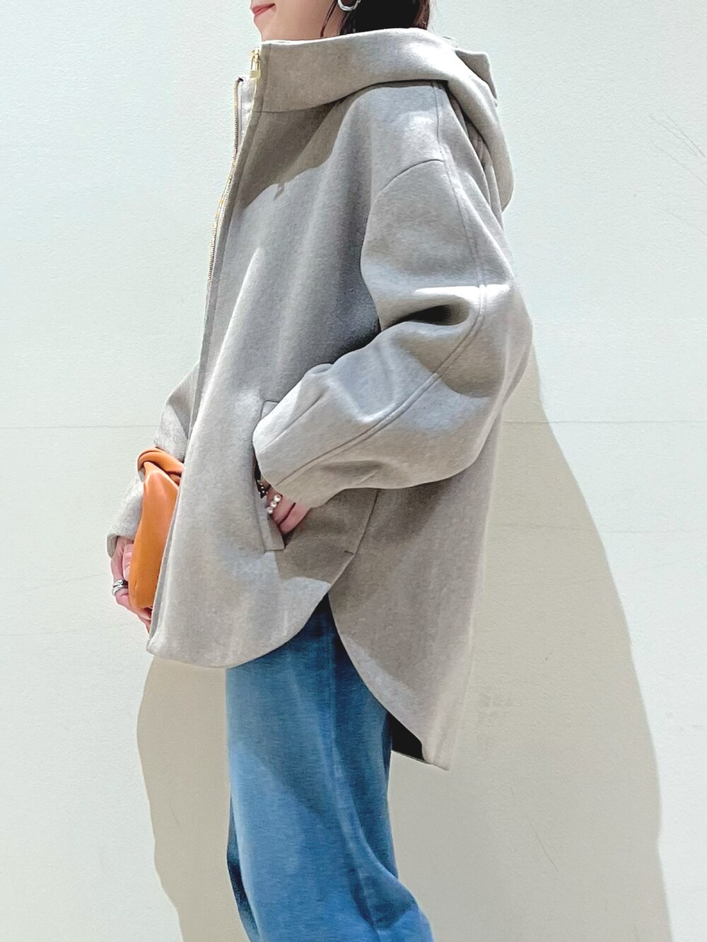 ブルー系のデニムパンツ、イエロー系のショルダーバッグ、グリーン系のニット/セーターを着用したレディースの秋コーディネートの4枚目の写真