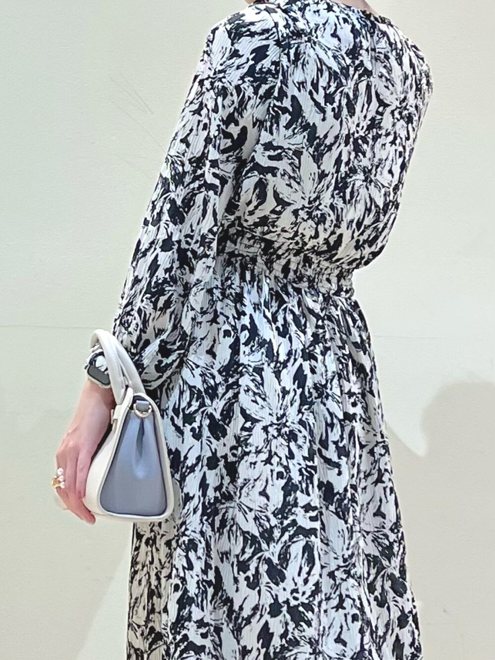 ベージュ系のパンプス、ブラック系のワンピース、ホワイト系のショルダーバッグを着用したレディースの冬コーディネートの4枚目の写真