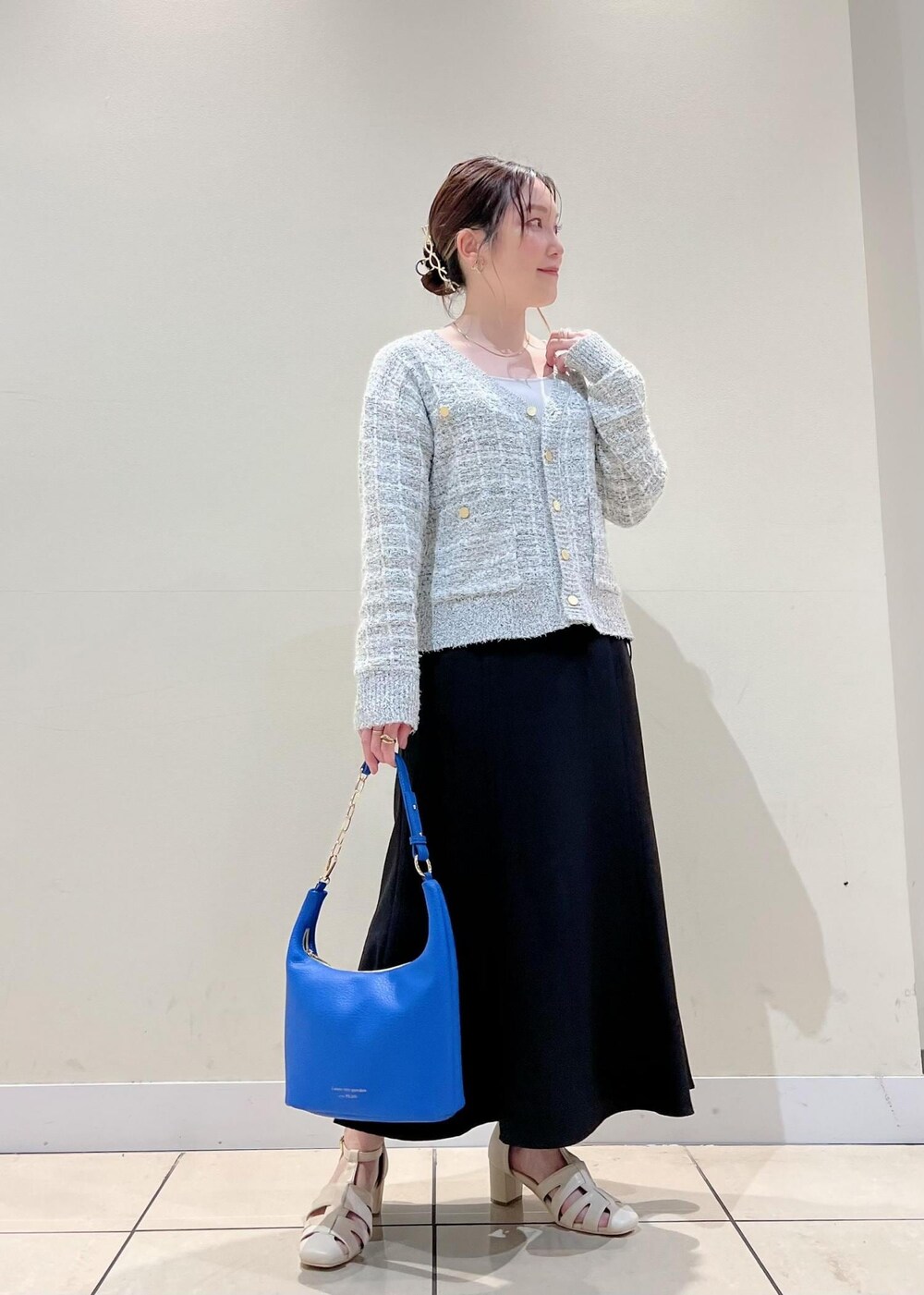 ホワイト系のサンダル、ブラック系のスカート、グレー系のカーディガン/ボレロを着用したレディースの春コーディネートの3枚目の写真