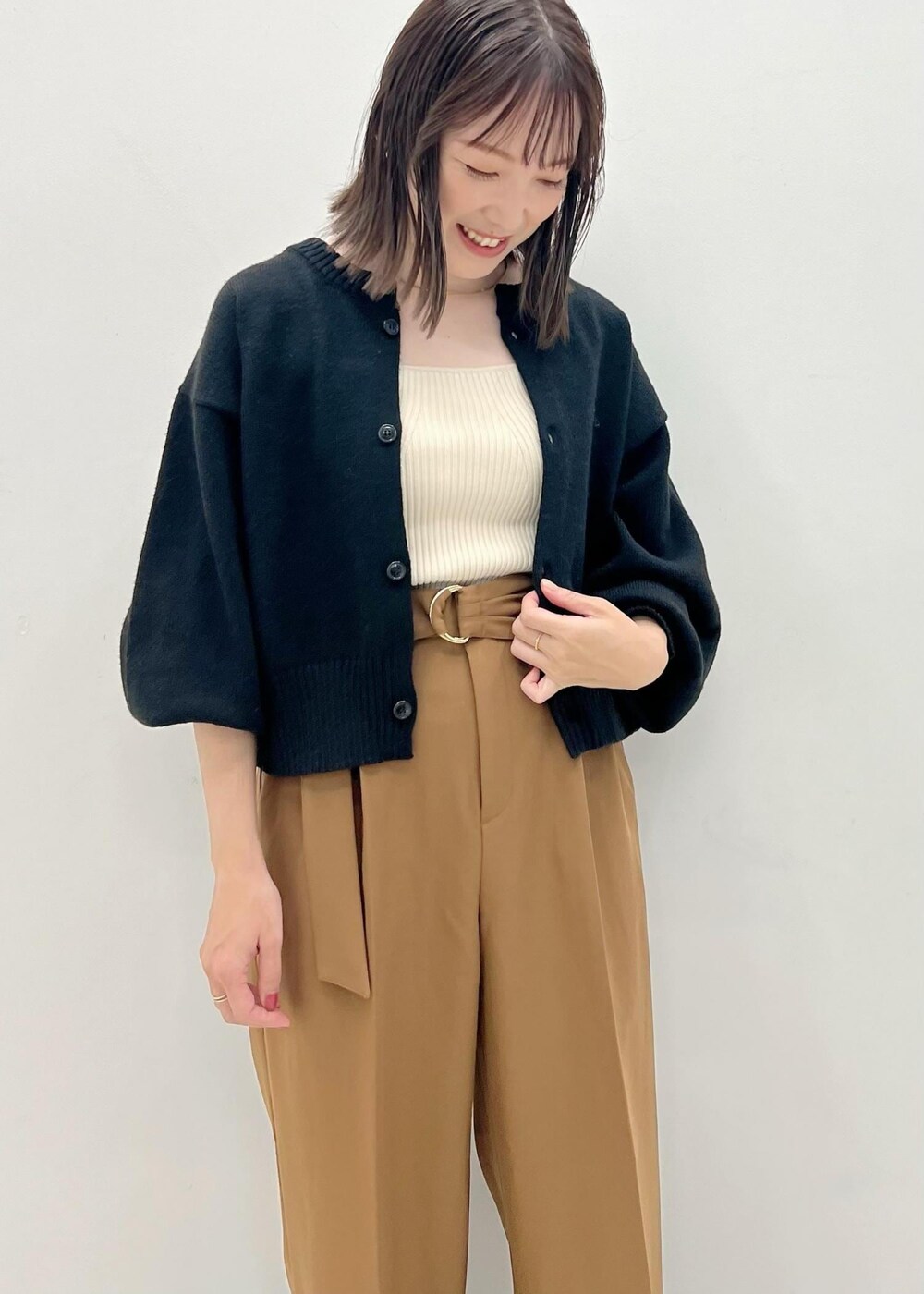 ブラック系のカーディガン/ボレロ、ホワイト系のベスト、ブラウン系のブーツを着用したレディースの秋コーディネートの5枚目の写真