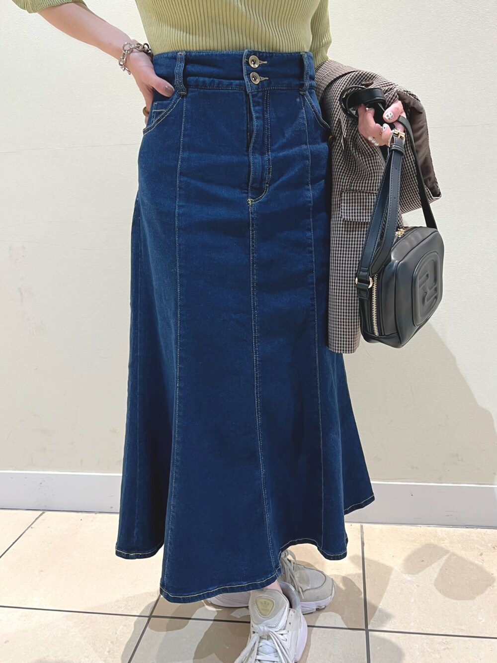 ブラック系のショルダーバッグ、ブラウン系のテーラードジャケット、ブルー系のデニムスカートを着用したレディースの夏コーディネートの2枚目の写真