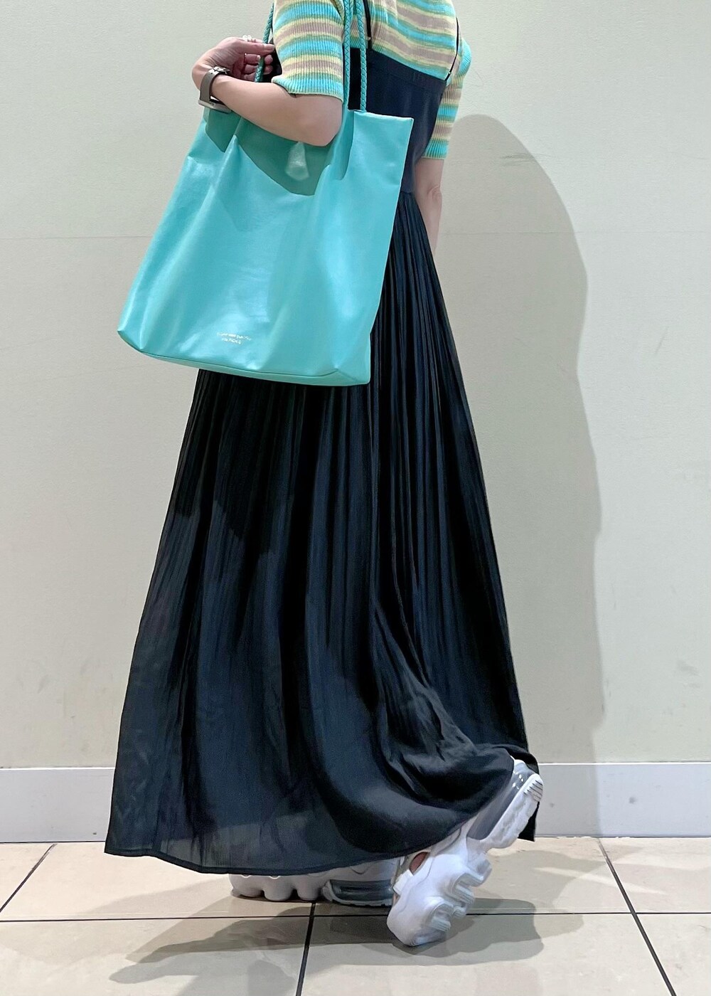 グリーン系のニット/セーター、グリーン系のトートバッグ、グレー系のワンピースを着用したレディースの夏コーディネートの3枚目の写真