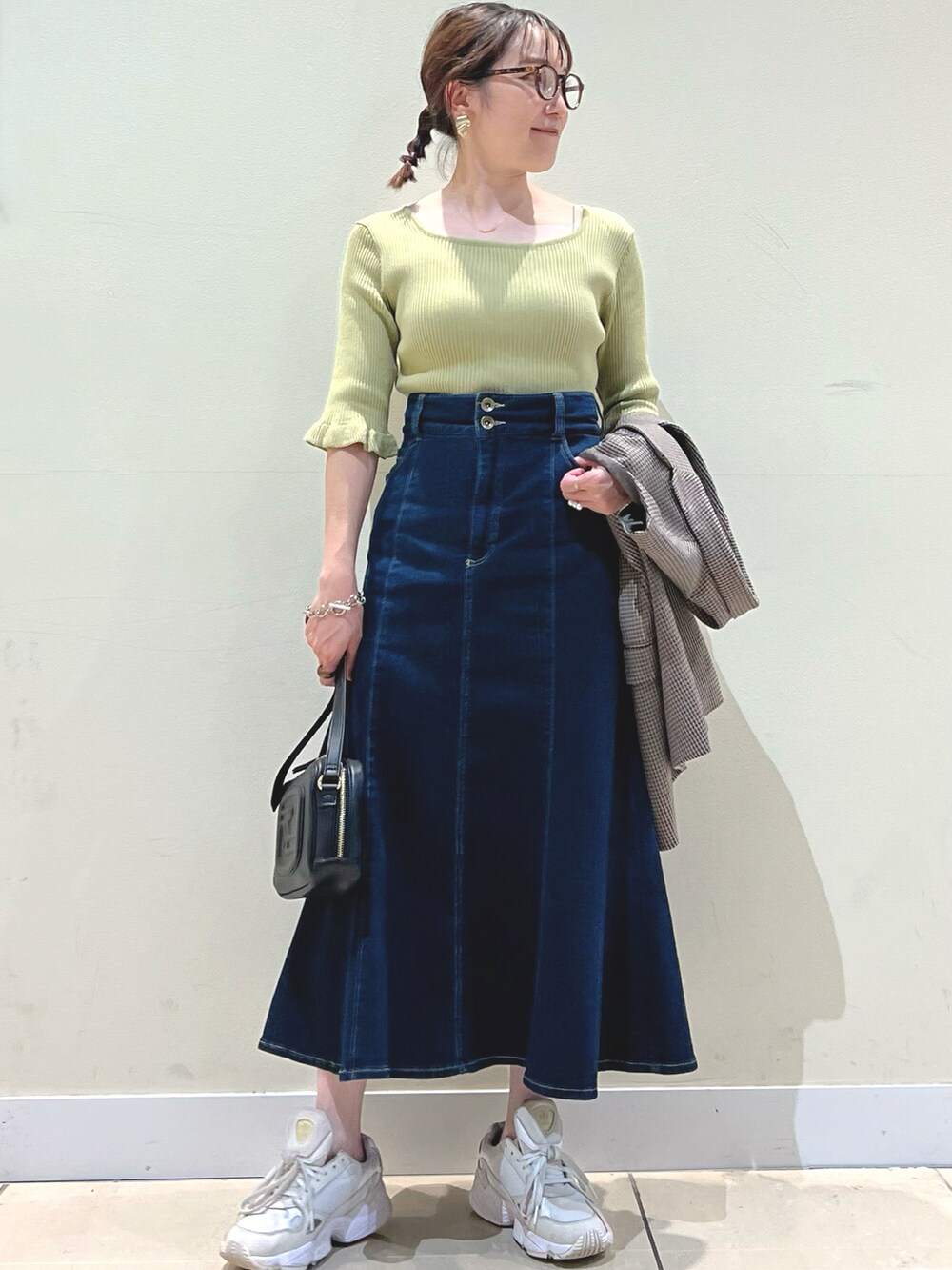 ブラック系のショルダーバッグ、ブラウン系のテーラードジャケット、ブルー系のデニムスカートを着用したレディースの夏コーディネートの5枚目の写真