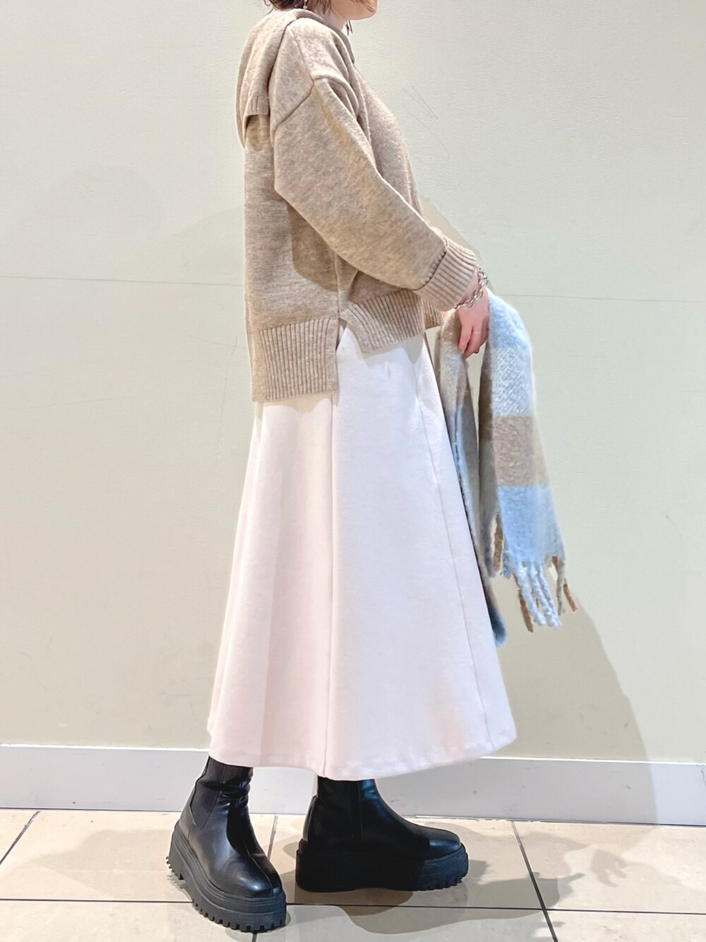 ベージュ系のニット/セーター、ピンク系のスカート、ブルー系のストール/ショールを着用したレディースの冬コーディネートの4枚目の写真