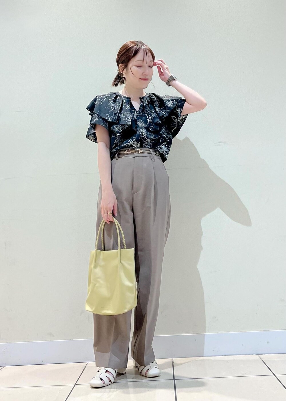 イエロー系のトートバッグ、ホワイト系のサンダル、ブラウン系のその他パンツを着用したレディースの夏コーディネートの5枚目の写真