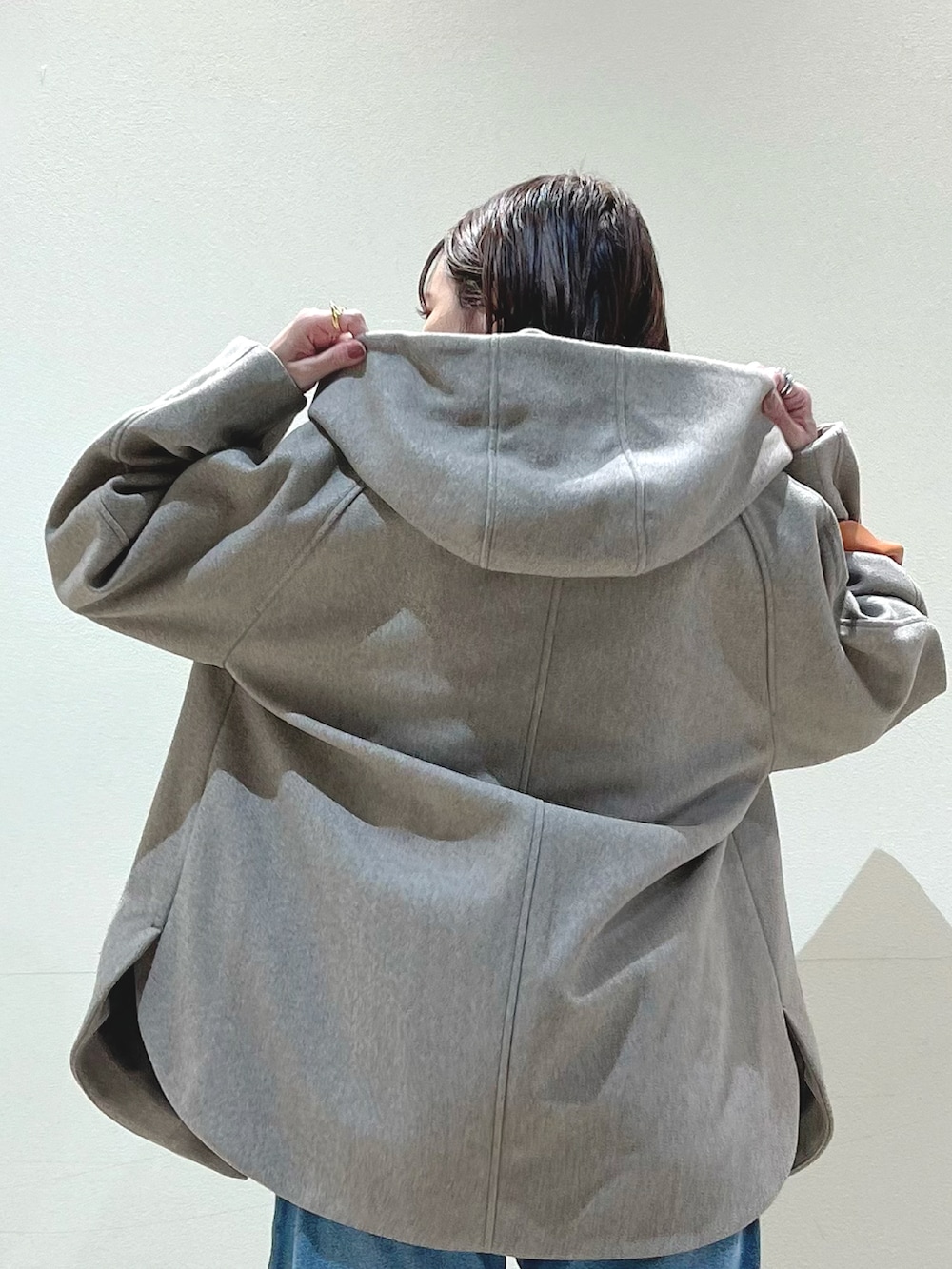 ブルー系のデニムパンツ、イエロー系のショルダーバッグ、グリーン系のニット/セーターを着用したレディースの秋コーディネートの3枚目の写真