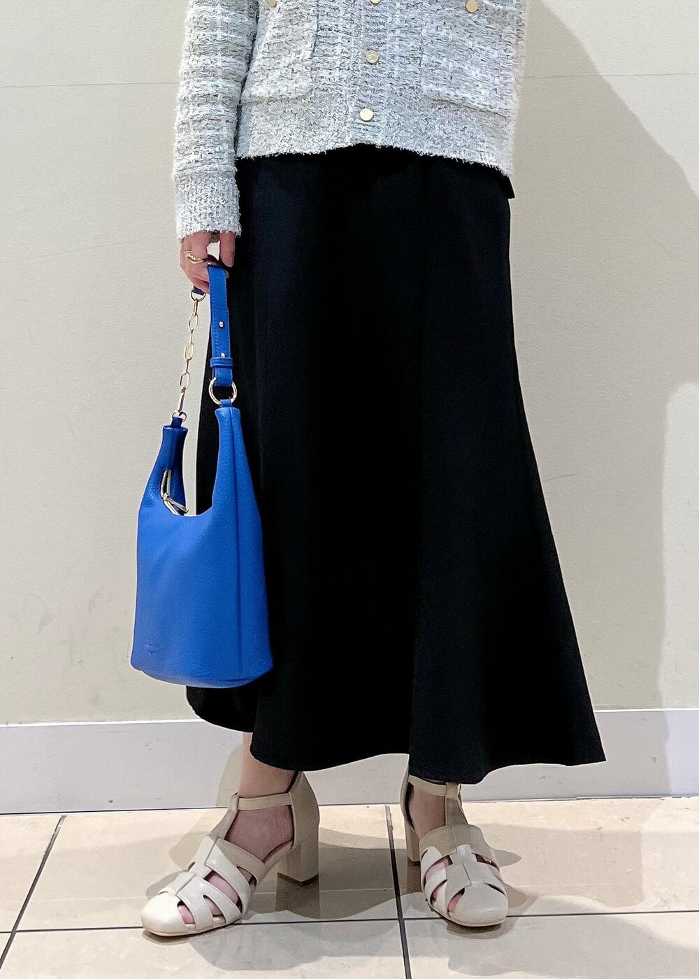 ホワイト系のサンダル、ブラック系のスカート、グレー系のカーディガン/ボレロを着用したレディースの春コーディネートの4枚目の写真