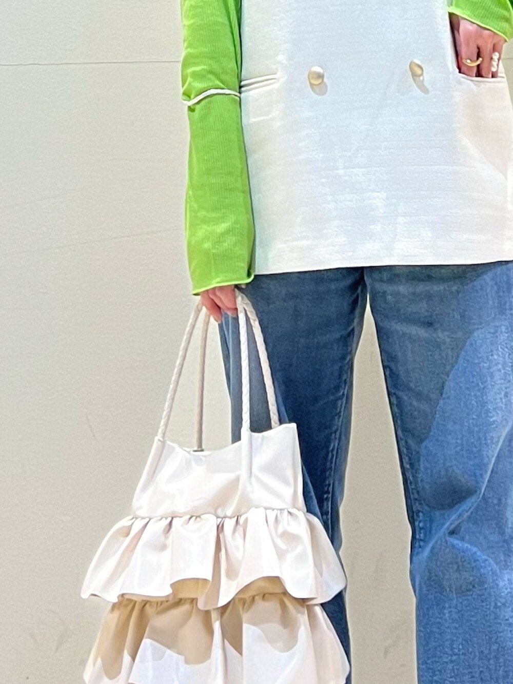 ホワイト系のベスト、グリーン系のTシャツ/カットソー、ブラック系のパンプスを着用したレディースの春コーディネートの3枚目の写真