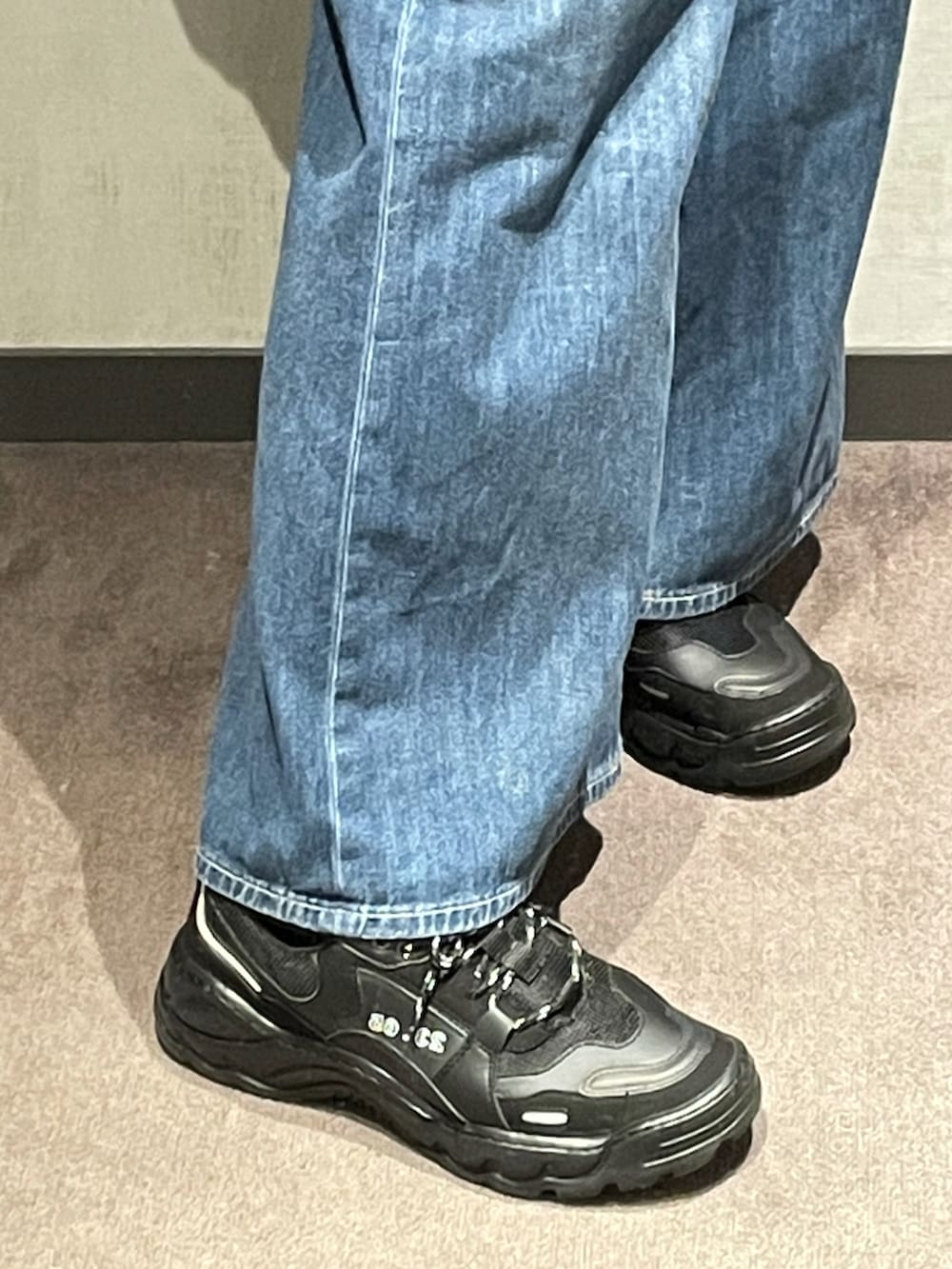 ブラック系のスウェット、ブラック系のパーカー、ブルー系のデニムパンツを着用したメンズの秋コーディネートの2枚目の写真