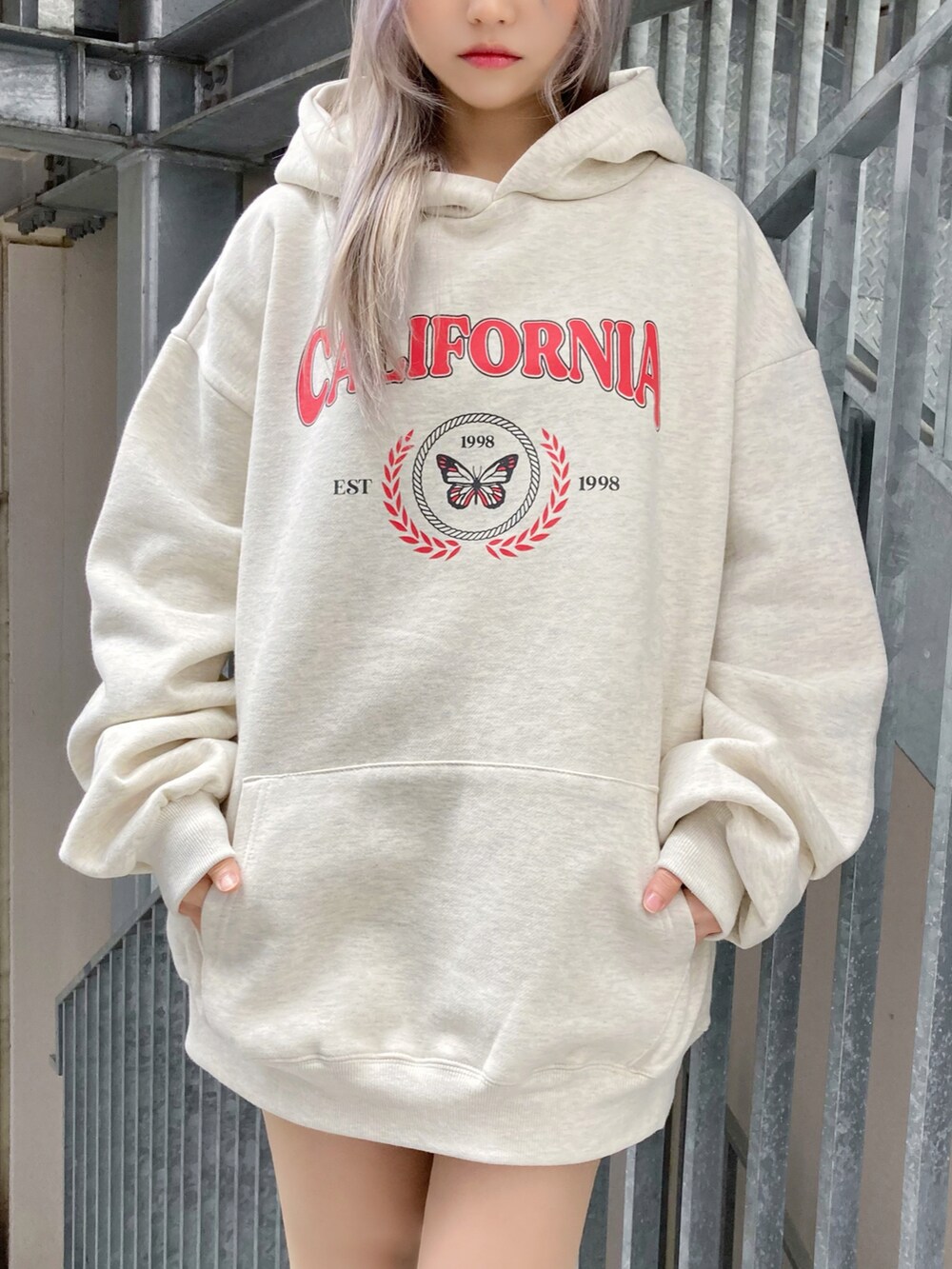 ホワイト系のトートバッグ、ベージュ系のパーカー、ホワイト系のスニーカーを着用したレディースの冬コーディネートの3枚目の写真